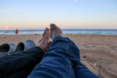 Low section of people relaxing on beach