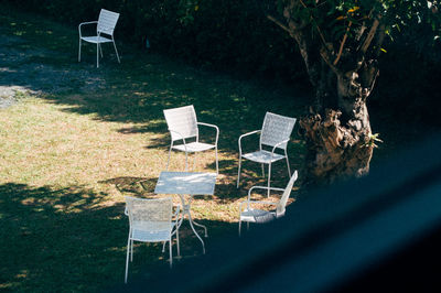 Empty chairs and tables in yard