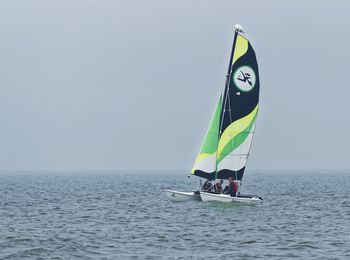 Sailboat in sea against clear sky