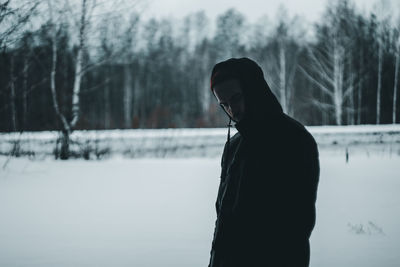 Side view of man standing on snow covered land