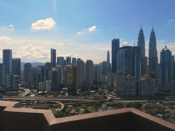 Buildings in city against cloudy sky