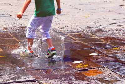 Low section of man standing in water