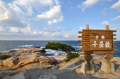 Signboard on beach against the sky