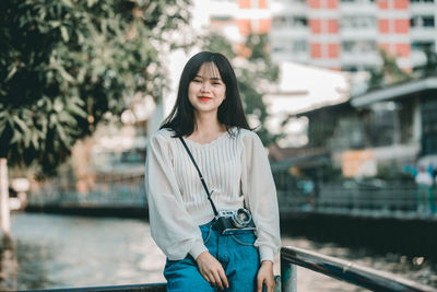 Portrait of smiling young woman standing outdoors