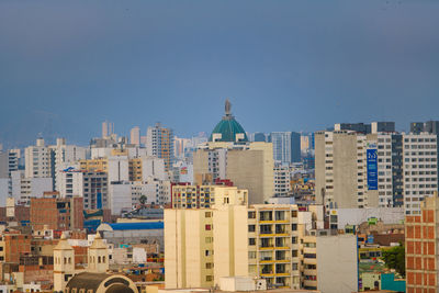 Buildings in city against clear sky