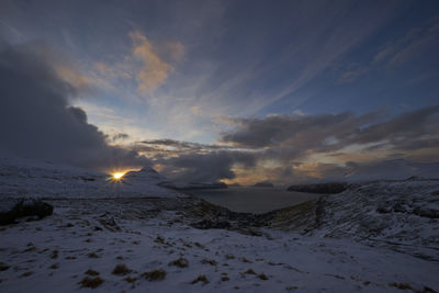 Scenic view of snow covered landscape against sky during sunset