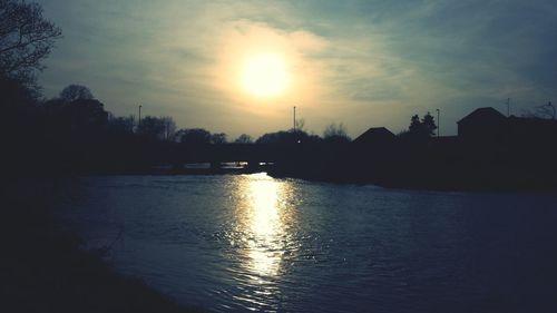 Scenic view of river against sky at sunset