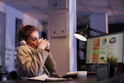 Young woman using mobile phone in office