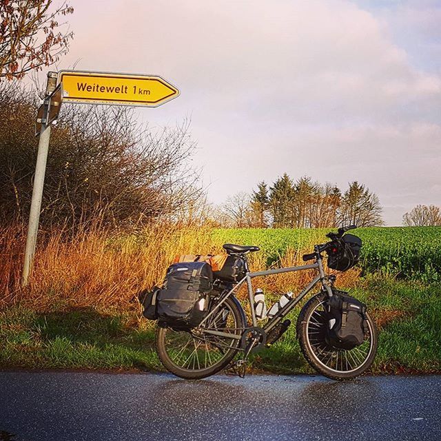 text, transportation, communication, bicycle, western script, information sign, road sign, land vehicle, mode of transport, tree, sign, guidance, warning sign, road, sky, grass, field, street, signboard, outdoors