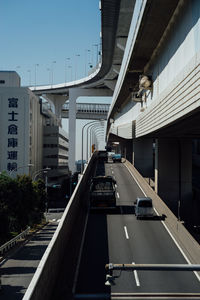 Vehicles on road amidst buildings in city against sky