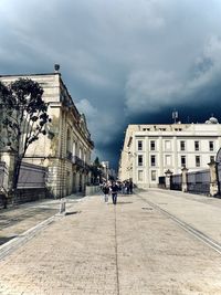 People walking on street against buildings in city