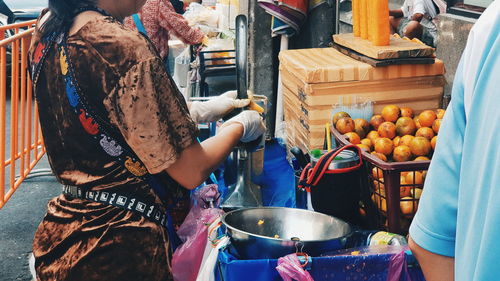 Midsection of man preparing food for sale at market