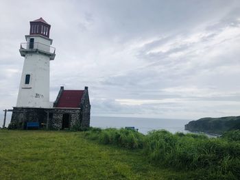 Lighthouse amidst buildings against sky