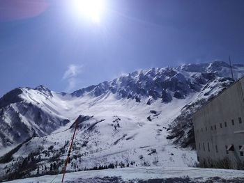 Scenic view of snowcapped mountains against sky on sunny day