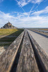 Surface level of railroad tracks against cloudy sky