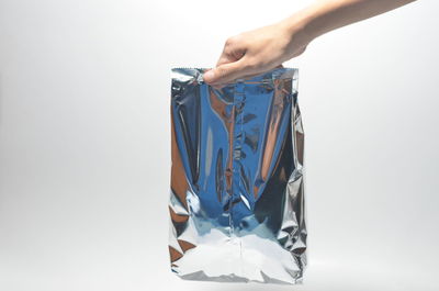 Midsection of person holding umbrella against white background