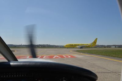 View of airport runway seen through car windshield