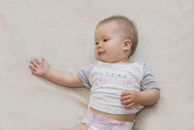 Beautiful baby in a diaper is lying on the bed