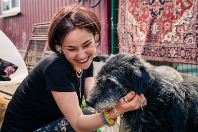 Side view of young woman holding dog