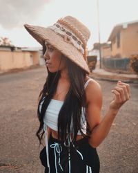 Portrait of young woman wearing hat standing outdoors