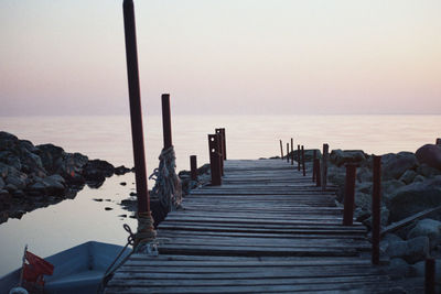 Wooden pier on sea against clear sky