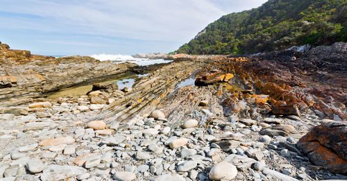 Stones on beach against sky