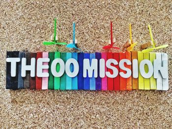 Directly above shot of text on colorful wooden blocks by toys over sand