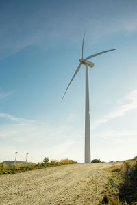 Wind turbine on field against sky