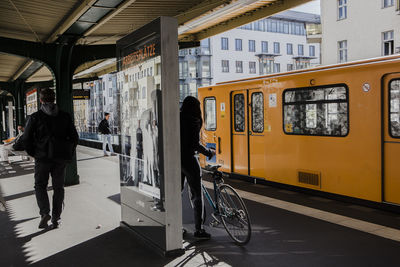 People on train at railroad station in city
