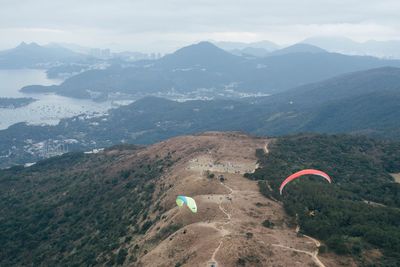 High angle view of people paragliding against mountains