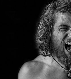 Portrait of shirtless man against black background