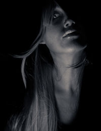 Close-up portrait of spooky woman in darkroom