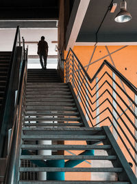 Low angle view of man walking up a staircase at the train station