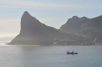 Scenic view of sea and mountains against sky