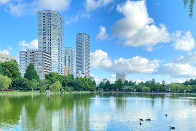 View of city by lake against sky