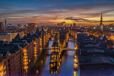 High angle view of illuminated buildings against sky during sunset