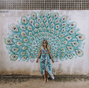 Portrait of woman standing against wall