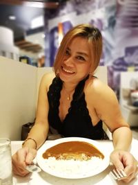 Portrait of a smiling young woman eating food