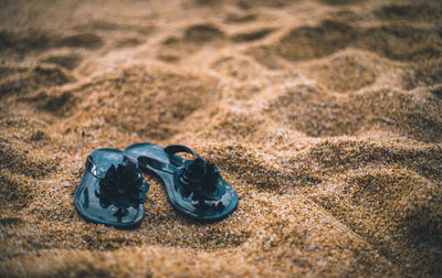 Close-up of shoes on sand