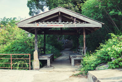 Gazebo amidst trees and house in forest