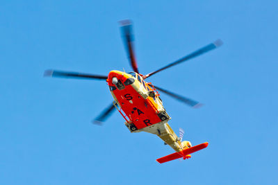 Low angle view of airplane against clear blue sky