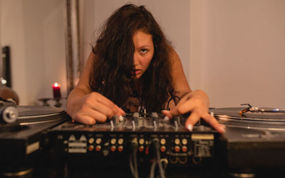 Close-up of fashionable young woman playing music at home