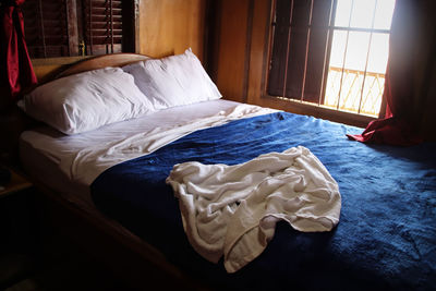 White image of messy bed in bedroom