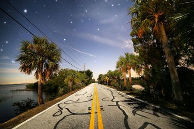 Road amidst trees against sky