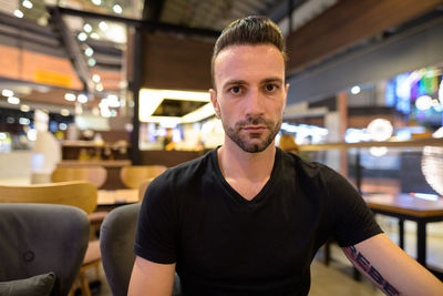 Portrait of young man sitting at cafe