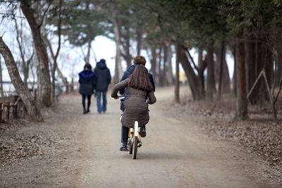 Rear view of man walking on footpath