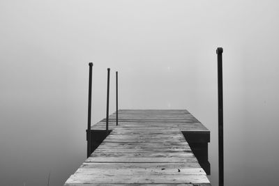 Wooden jetty on pier against sky