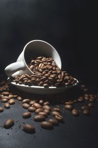 Close-up of coffee beans on table against black background