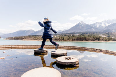 Full length of woman standing on lake