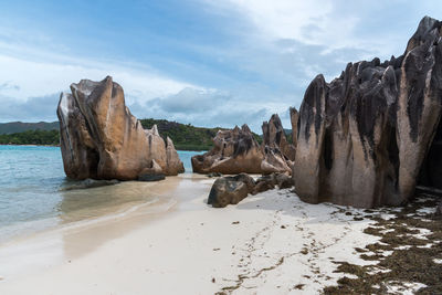 Rock formations on beach against sky